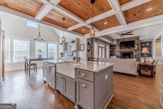 kitchen featuring stainless steel dishwasher, decorative light fixtures, a kitchen island with sink, and wooden ceiling