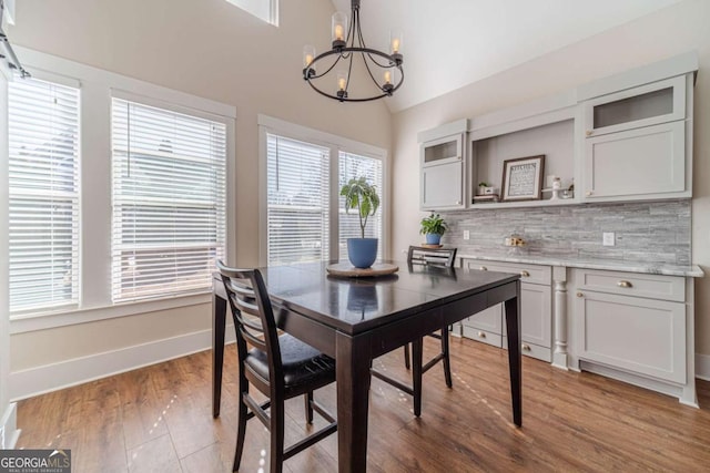 dining space featuring lofted ceiling, dark hardwood / wood-style floors, and a chandelier