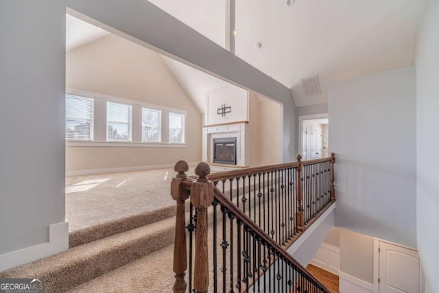 stairs with lofted ceiling and carpet flooring