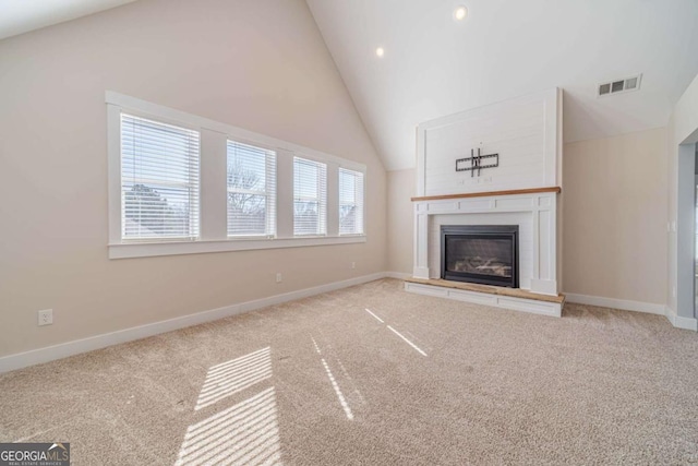 unfurnished living room featuring high vaulted ceiling and carpet floors