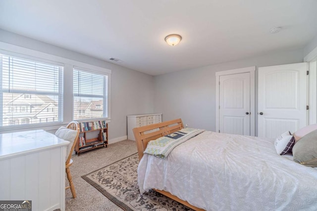 bedroom featuring light colored carpet and a closet