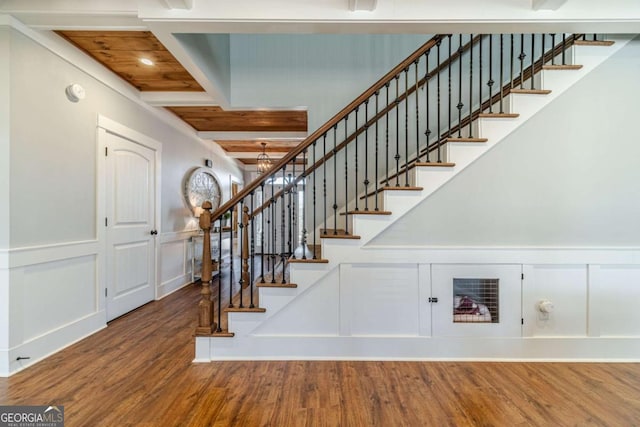 staircase featuring beamed ceiling and hardwood / wood-style floors