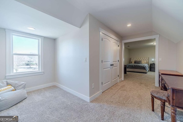 hallway with light carpet and lofted ceiling