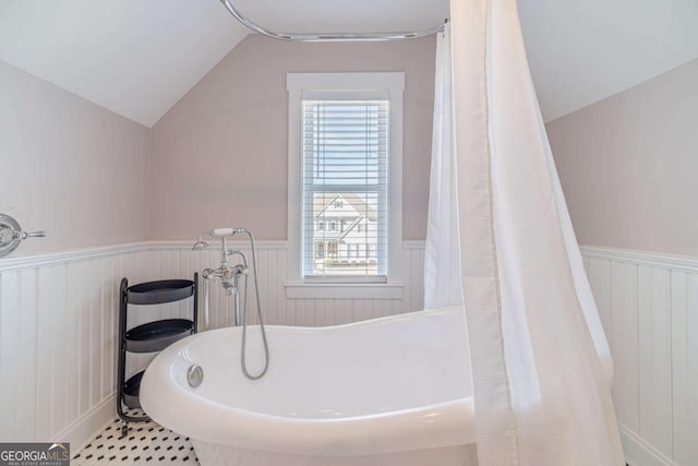 bathroom with a bathtub and vaulted ceiling