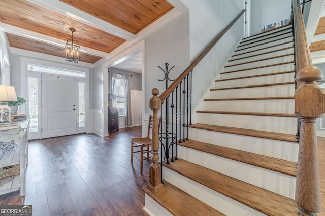 entrance foyer with beamed ceiling, dark wood-type flooring, a wealth of natural light, and wooden ceiling