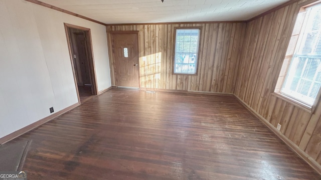 unfurnished room with ornamental molding and dark wood-type flooring