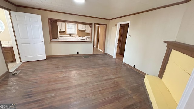 unfurnished living room featuring ornamental molding, dark hardwood / wood-style flooring, and sink