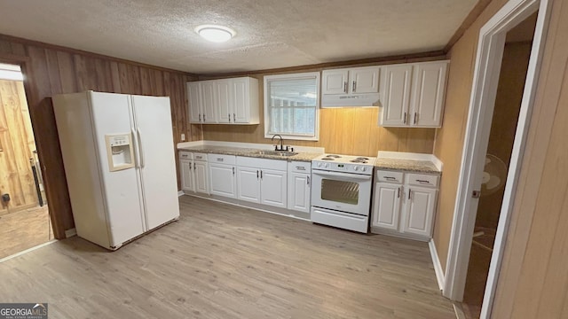 kitchen with sink, a textured ceiling, white appliances, light hardwood / wood-style floors, and white cabinets