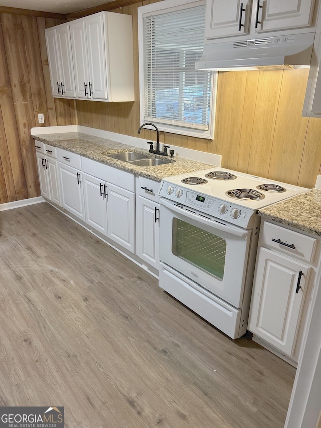 kitchen featuring wood walls, white electric range, sink, and white cabinets