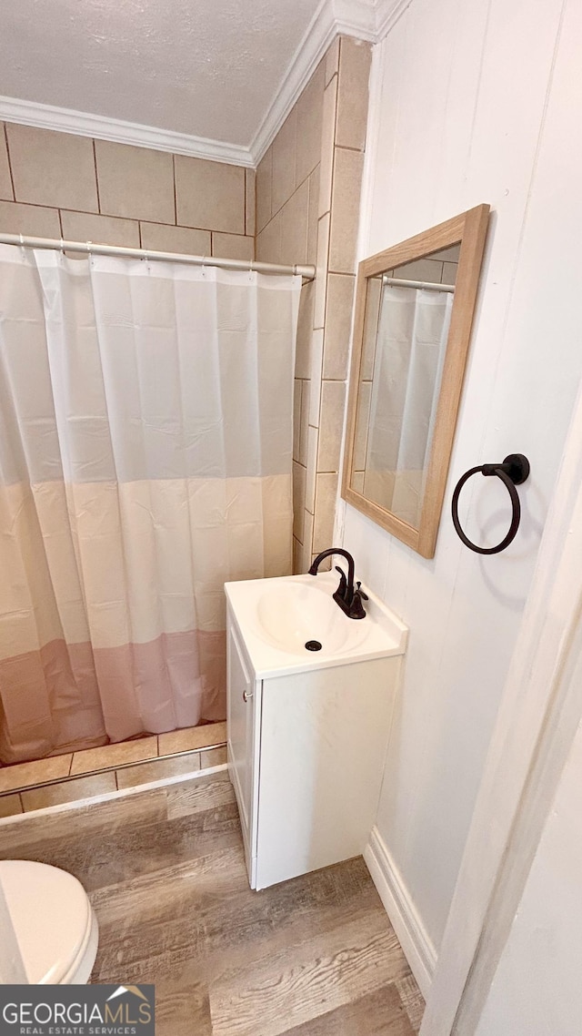 bathroom featuring crown molding, hardwood / wood-style flooring, vanity, a shower with curtain, and toilet