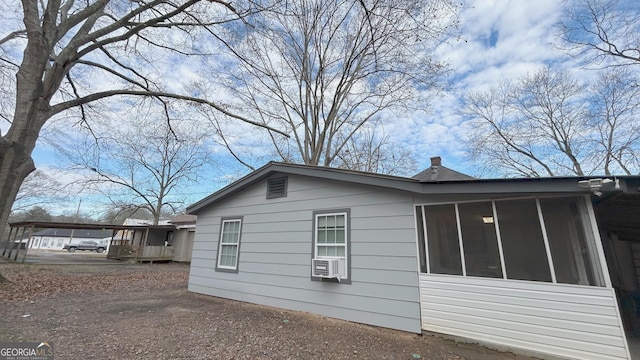 view of property exterior featuring a sunroom and cooling unit