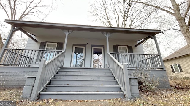 view of exterior entry featuring covered porch