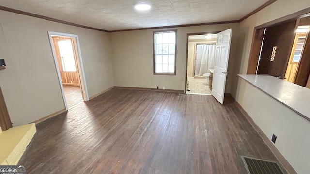 empty room featuring crown molding and dark hardwood / wood-style floors