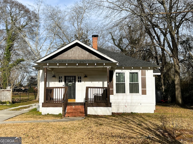 bungalow-style home featuring a front yard and covered porch