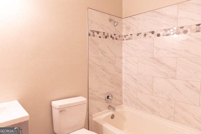 full bathroom featuring tiled shower / bath combo, vanity, and toilet