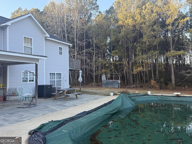 view of swimming pool with a diving board and a patio