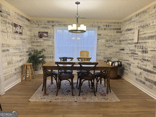 dining area featuring a notable chandelier, dark hardwood / wood-style floors, and a textured ceiling