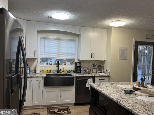 kitchen with white cabinets, black dishwasher, sink, and refrigerator with ice dispenser