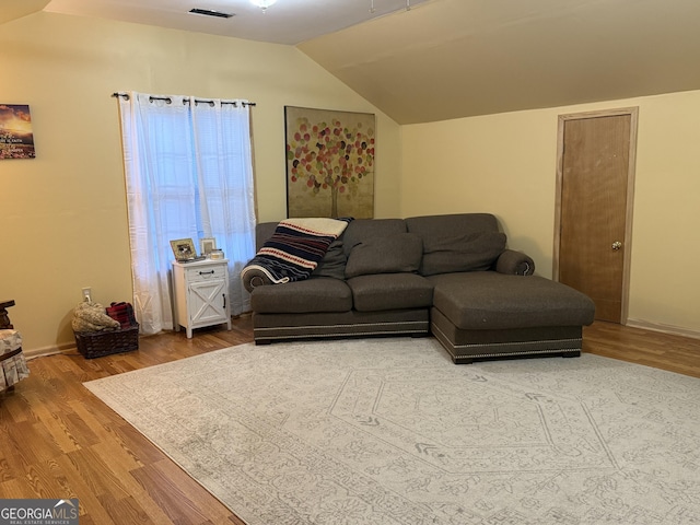 living room featuring lofted ceiling and hardwood / wood-style floors