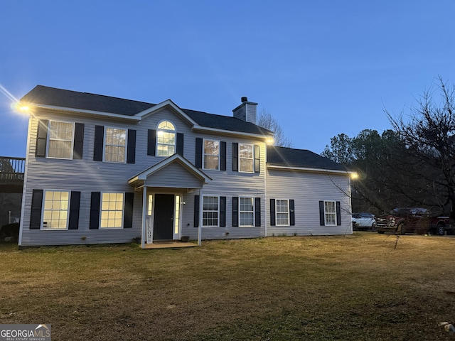 colonial-style house featuring a lawn