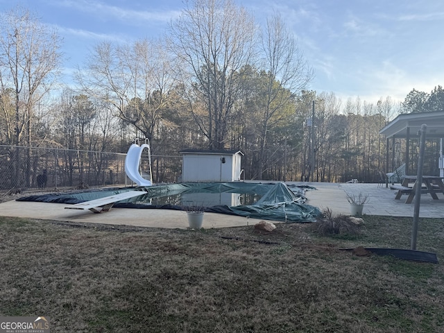 view of yard with a shed, a patio area, and a covered pool