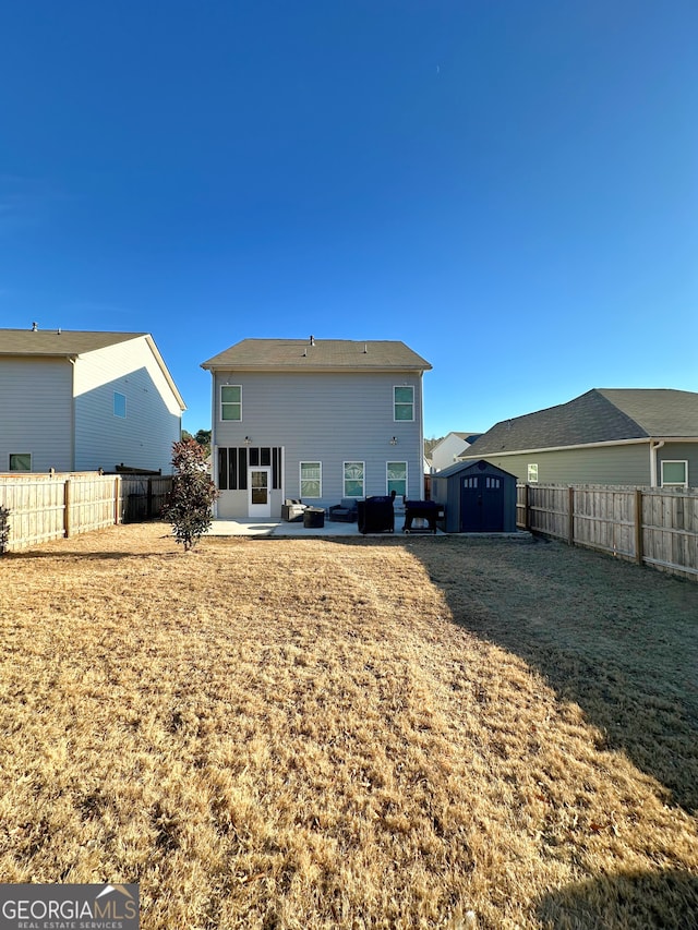 back of house featuring a patio, a yard, and a storage shed