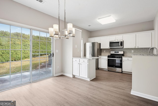 3742 Berkeley Xing, Duluth, GA 30096 - kitchen with an inviting chandelier, white cabinetry, decorative backsplash, wood finished floors, and appliances with stainless steel finishes