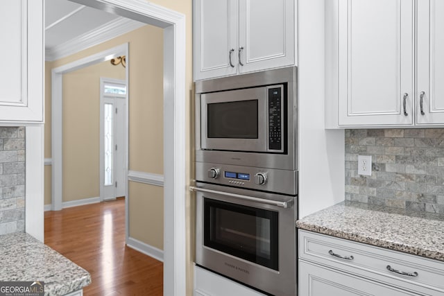 kitchen with white cabinetry, light stone countertops, and appliances with stainless steel finishes