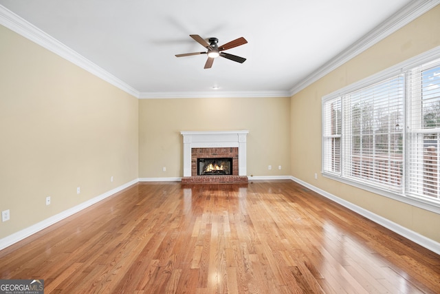 unfurnished living room with ceiling fan, ornamental molding, light hardwood / wood-style floors, and a brick fireplace