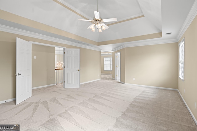 carpeted empty room with ornamental molding, a raised ceiling, and ceiling fan