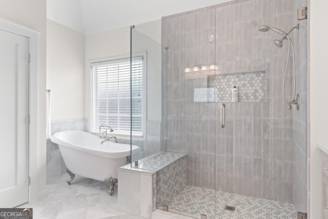 bathroom with lofted ceiling, separate shower and tub, and tile walls