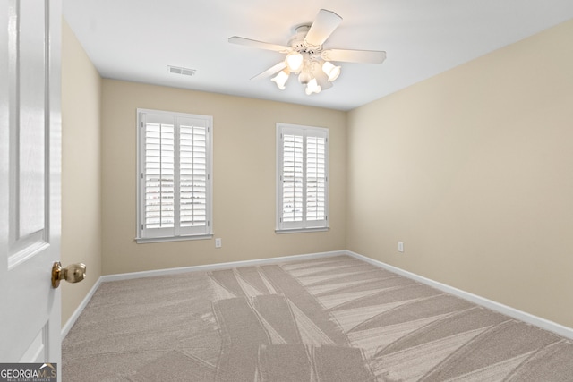 carpeted empty room featuring a wealth of natural light and ceiling fan