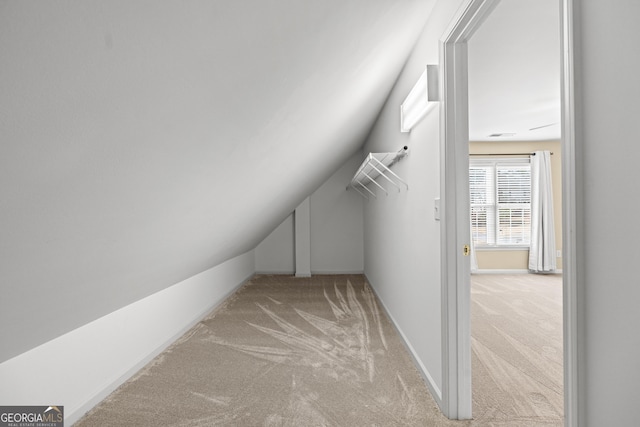 interior space with light carpet and vaulted ceiling