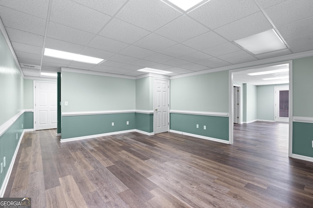 basement featuring dark wood-type flooring and a paneled ceiling