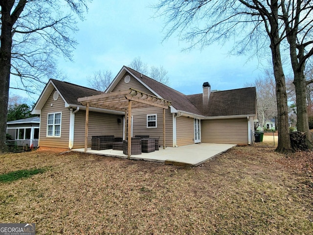 rear view of property featuring a pergola, a patio area, and a lawn