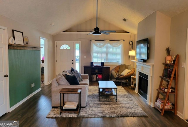 living room with ceiling fan, dark hardwood / wood-style flooring, and vaulted ceiling