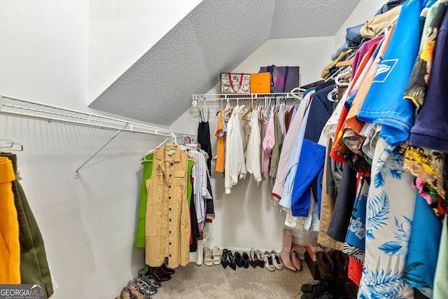 spacious closet featuring vaulted ceiling and carpet