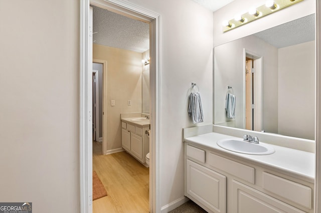 bathroom featuring vanity, hardwood / wood-style floors, and a textured ceiling