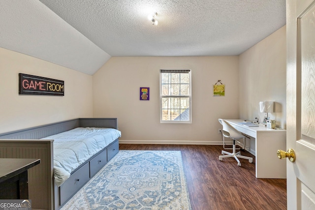 bedroom with dark wood-type flooring, a textured ceiling, and vaulted ceiling