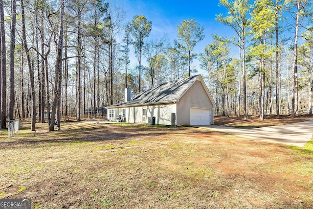 view of side of home featuring a garage, a yard, and cooling unit