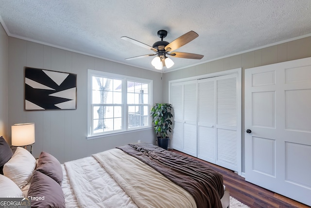 bedroom featuring dark hardwood / wood-style floors, ornamental molding, ceiling fan, a textured ceiling, and a closet