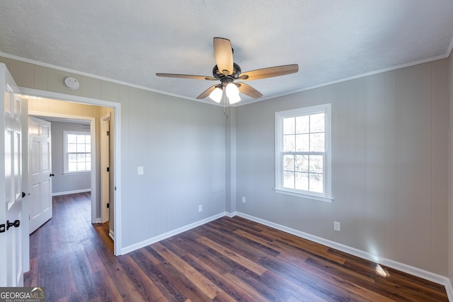 empty room with ceiling fan, ornamental molding, dark hardwood / wood-style floors, and a textured ceiling