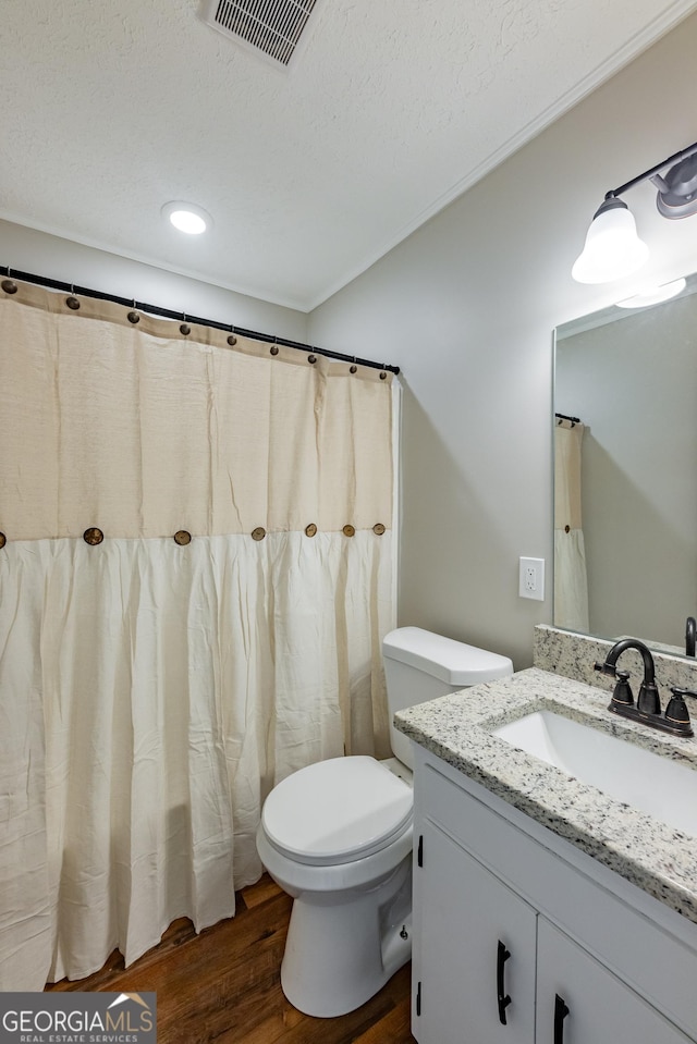 bathroom with vanity, hardwood / wood-style flooring, toilet, and a textured ceiling