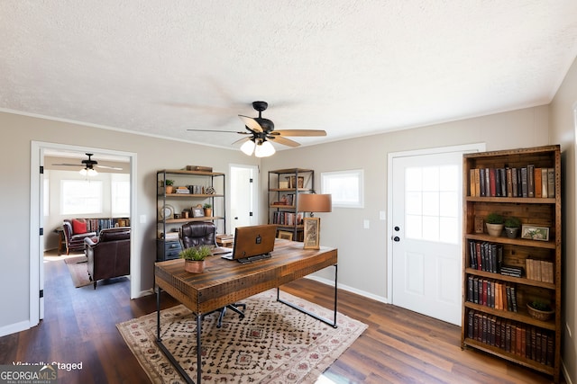 home office with plenty of natural light, dark wood-type flooring, and a textured ceiling