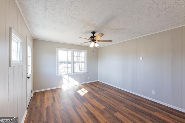 unfurnished room with a healthy amount of sunlight, dark hardwood / wood-style floors, a textured ceiling, and ceiling fan