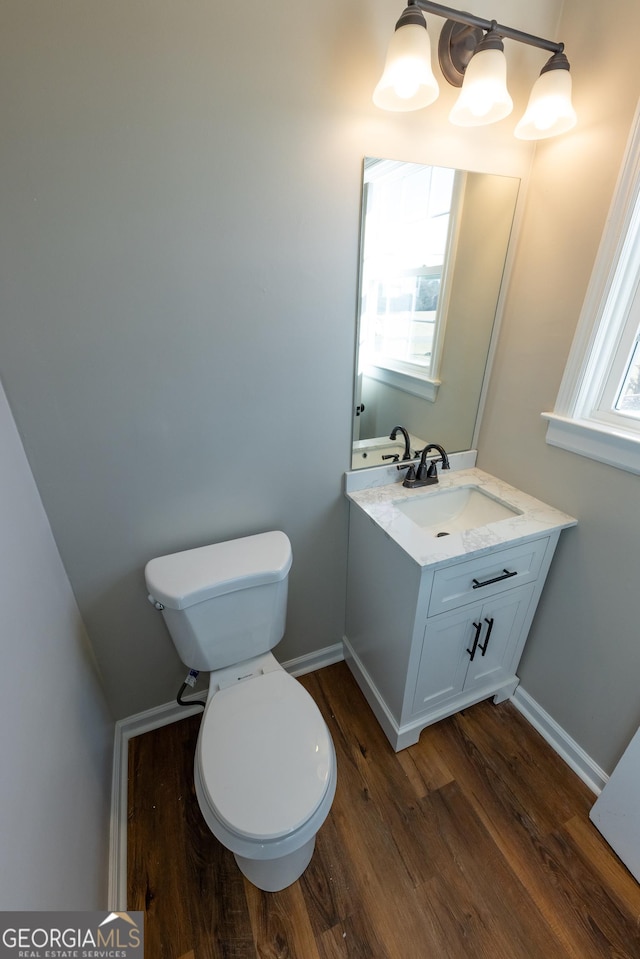 243 College St, Yatesville, GA 31097 - bathroom featuring wood finished floors, toilet, vanity, and baseboards