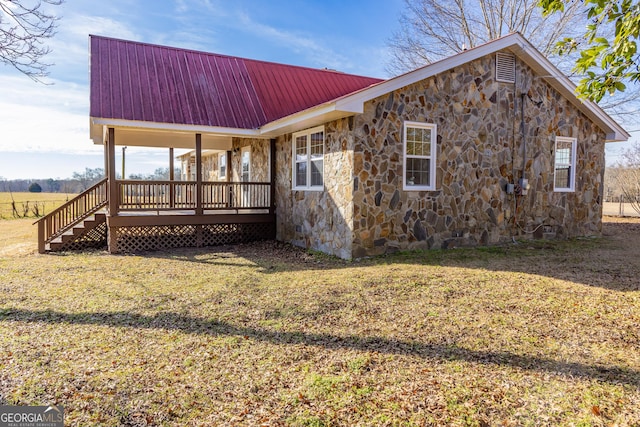 view of side of property featuring a yard and covered porch