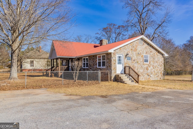 243 College St, Yatesville, GA 31097 - view of front of house with stone siding, a chimney, and metal roof