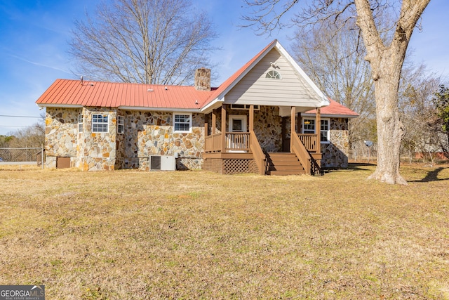 view of front of home featuring cooling unit, covered porch, and a front lawn