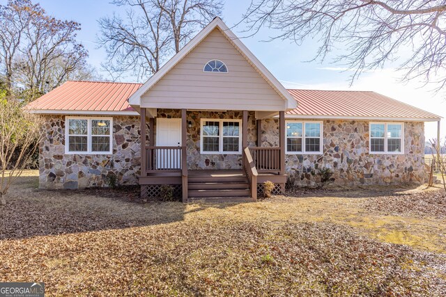243 College St, Yatesville, GA 31097 - view of front of house with stone siding, covered porch, and metal roof